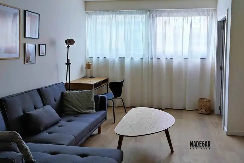Cortinas fruncidas a medida de semi-lino en color natural para ventanal de salón de estilo nórdico funcional con muy buen gusto en un estudio en el centro histórico del Gòtic Barcelona.