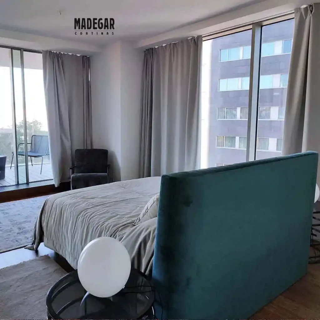 Cortinas opacas blackout grises a medida de suelo a techo instaladas en los grandes ventanales de un dormitorio principal de diseño contemporáneo en Barcelona.