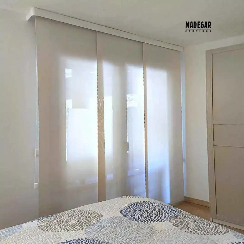 Paneles planos mimetizados en trejido de screen de color blanco dentro de una habitación minimalista junto a un armario empotrado.