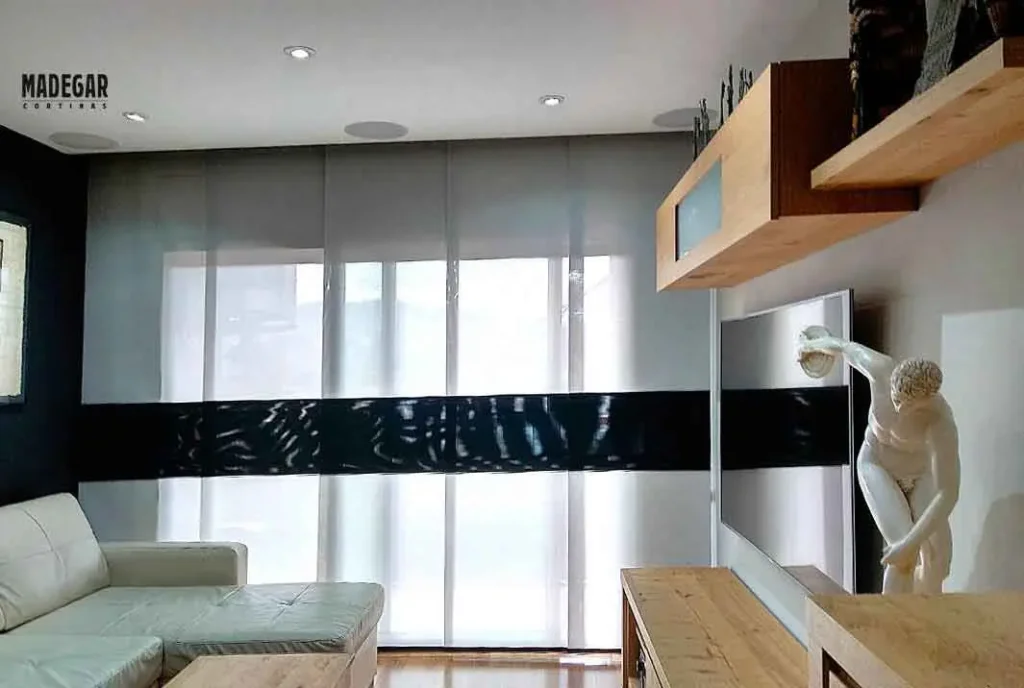 Panel japonés de screen decorativo en gris claro con una franja horizontal negra a media altura, instalado en un salón de estilo nórdico y detalles eclécticos en la Villa Olímpica de Barcelona.