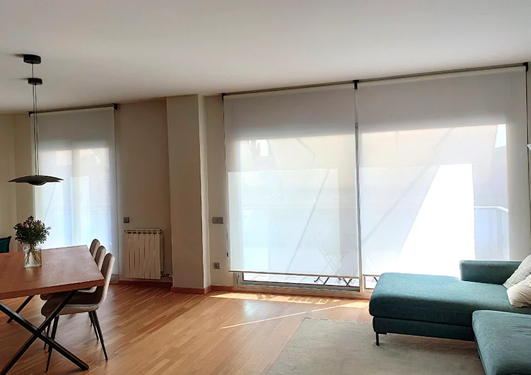 Estores enrollables de Screen a medida en un salón con ventanas grandes de Cortinas Madegar