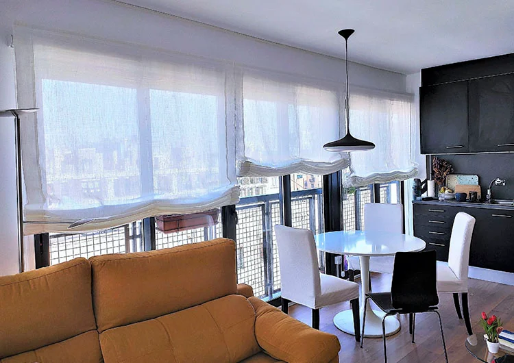 Estores tipo paqueto de lino en color natural para un apartamento con cocina abierta al salón confecionados e instalados por Cortinas Madegar