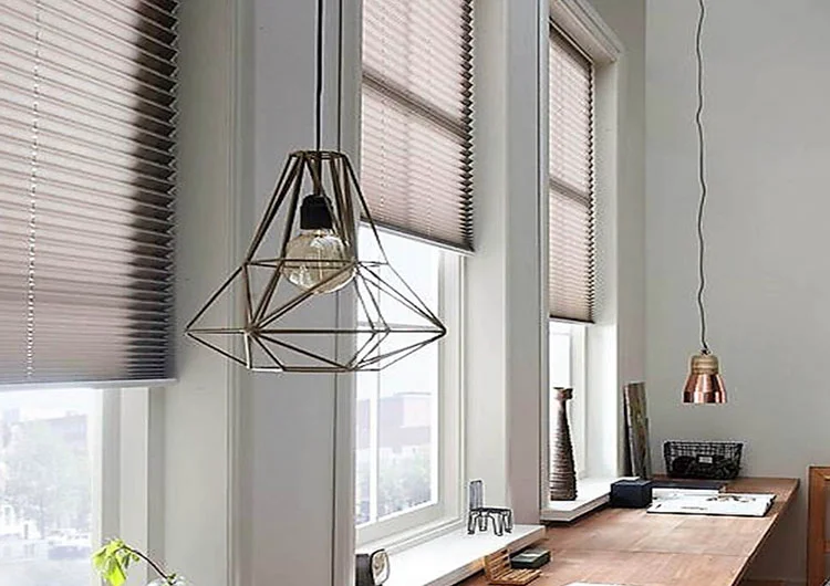 Cortinas Plisadas a medida instaladas en el marco de la ventana en un despacho de un apartemento en Barcelona