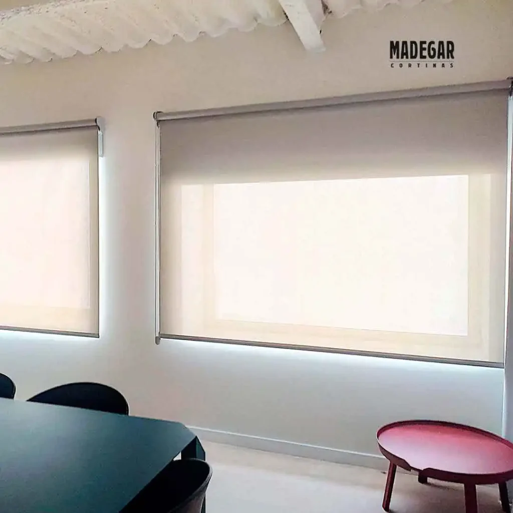 Estores screen a medida para control solar eficiente en oficinas. Los estores filtran la luz exterior eliminando reflejos en pantallas, ideales para espacios de trabajo tecnológicos.