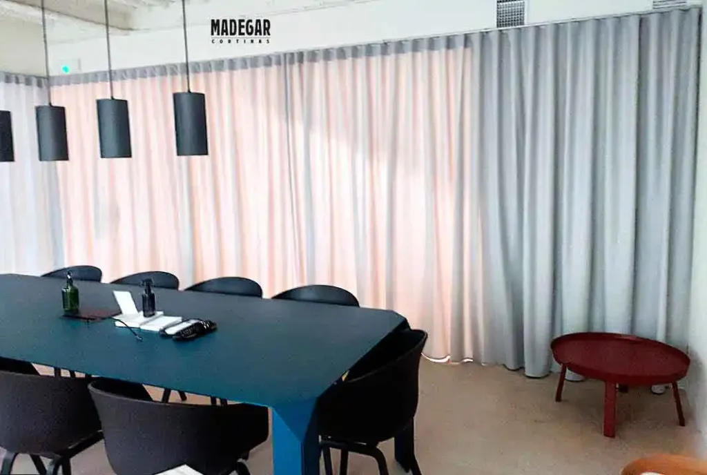 División de espacios corporativos con cortinas técnicas fonoabsorbentes. Una solución de Madegar Cortinas para reducir la reverberación en oficinas diáfanas y mejorar el confort acústico.