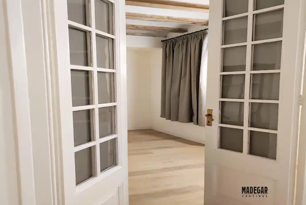 Visillos opacos instalados en los cristales de unas puertas en un apartamento des estilo escandinavo moderno en Barcelona