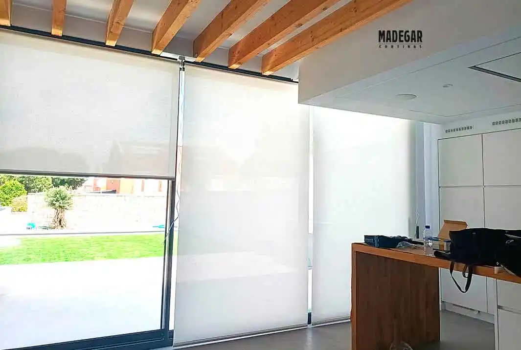 Estores Enrollables de Screen motorizados en color natural para ventanal de salida al jardín en una casa de Alto standing cerca de Barcelona