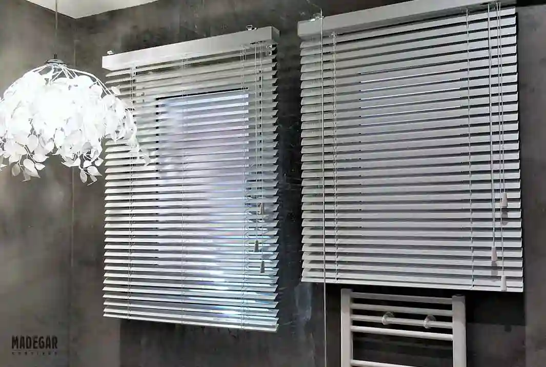Cortinas venecianas de aluminio en blanco en las ventanas de un baño de grandes dimensiones en una casa de Alella