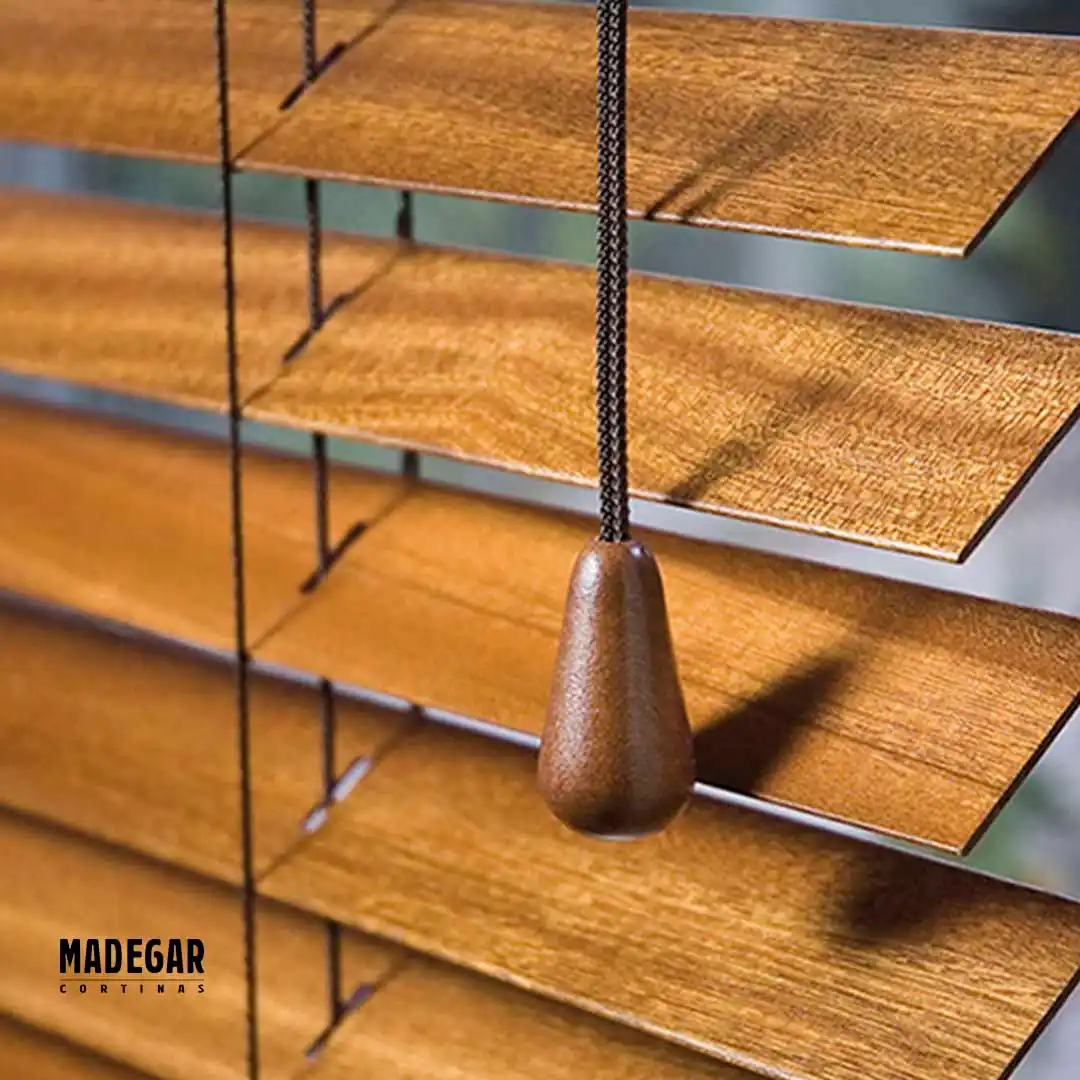 Detalle de personalización de unas cortinas venecianas de madera que se recogon con escalerilla, un cordon del mismo color que la madera