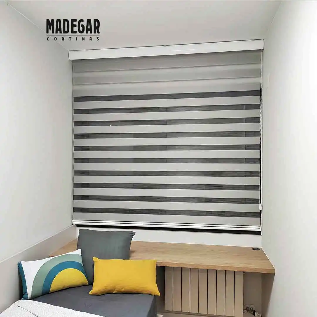 Estore enrollable noche y dia en color gris para la ventna de una habitación juvenil con el escritorio debajo, trabjo a medida de Cortinas Madegar