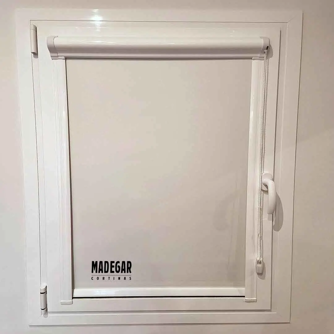 Estor blackout encajado en el junquillo de una venentan oscilibatiente hecho a medida por Cortinas madegar en Barcelona