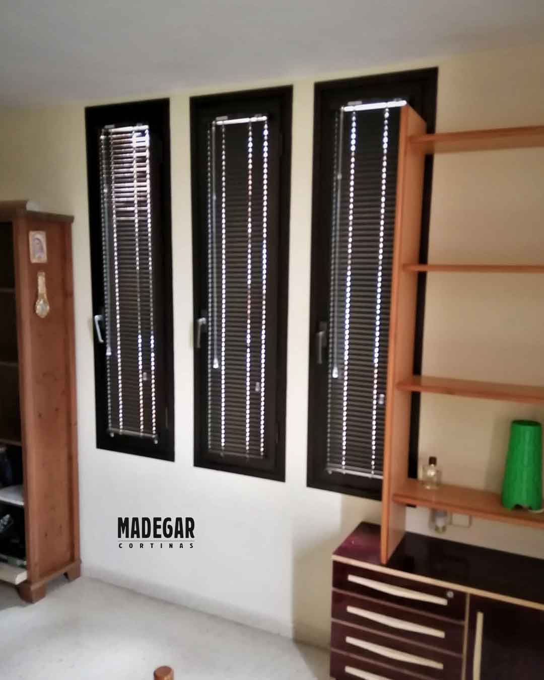 Cortinas Venecianas de Alimnio en negro instladas por Madegar en el junquillpo de tres ventanas estrechas y abatibles del la rectoria de una Parroquia en el barrio de Sant Martí de BArcelona
