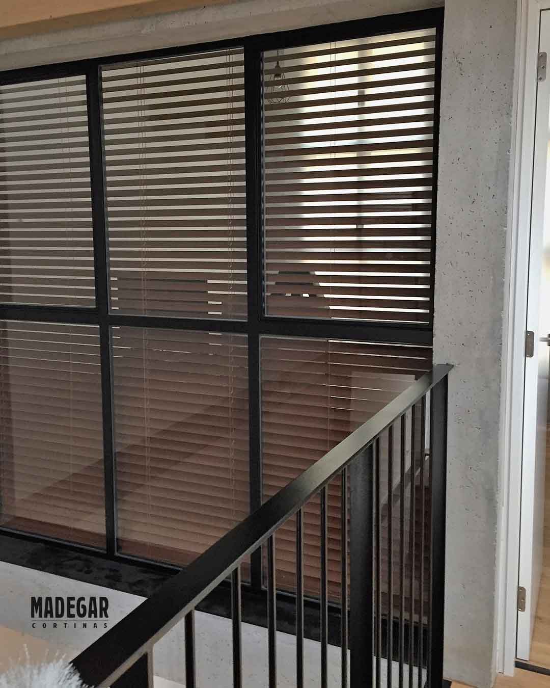 Cortina Veneciana de Maderea para graduar la visivilidad de una cristalera grande que da a la escalera de una vivienda unifamiliar en el Poblenou