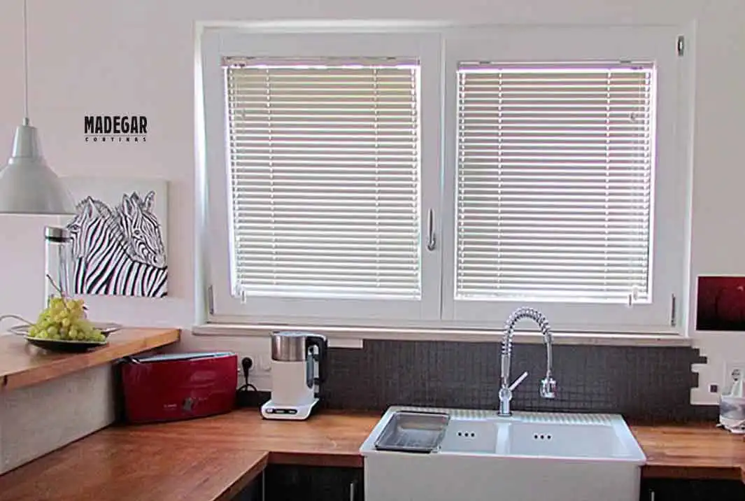 Cortinas Venecianas de Aluminio en blanco instaladas por cortinas Madegar en el junquillo de las ventanas oscilobatientes de la cocina  de estilo contemporáneo de una piso en Gracia