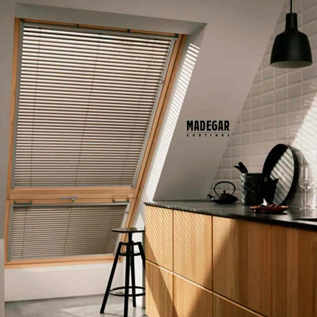 Cortina veneciana de alumnio en una ventana abuhardillada de una casa de estilo moderno en Castelldefels, la veneciana está guiada con cable para que no se balancee, solución a medida de Cortinas Madegar