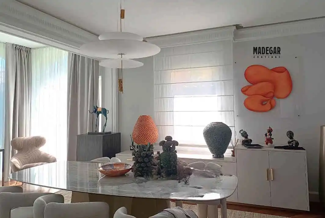 Combinación de dobles cortinas y estor con varillas en las diferentes ventanas de un salón elegante de una casa de alto standing en Castelldefels