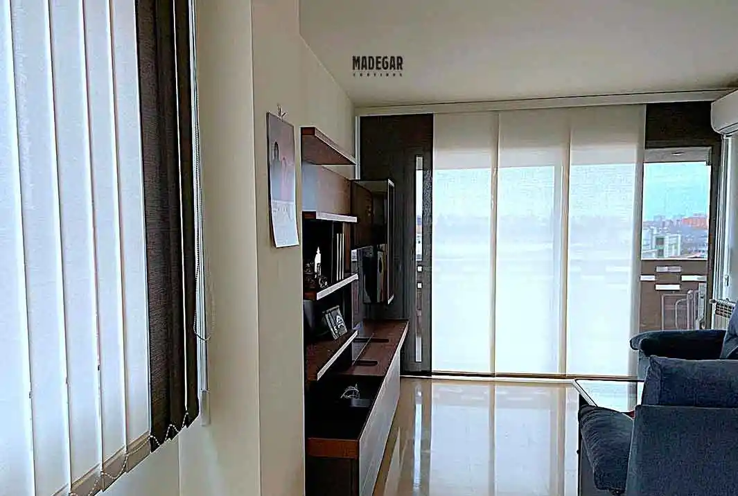 Cortinas de Screen en los diferentes espacios del un salón muy luminoso para protección solar y termica, panel japones para el vetanal grande y cortinas verticales para el resto de ventanas, soluciones en cortinas a medida de Cortinas Madegar en Barcelona