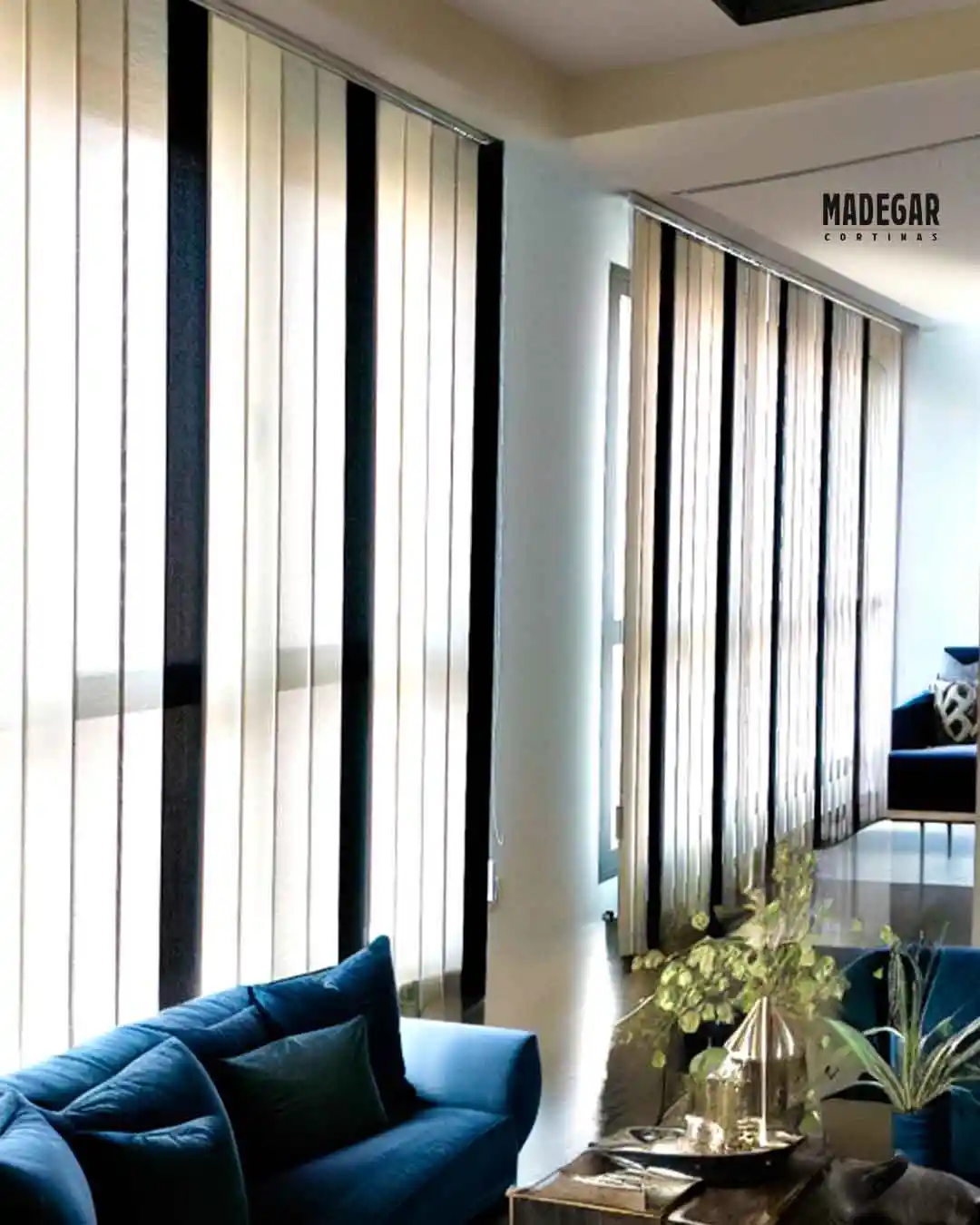 Cortinas verticales a medida en tejido screen bicolor instaladas en el salón común de un hotel en el Eixample, Barcelona. El sistema de Madegar Cortinas permite una regulación precisa de la luz natural en grandes ventanales.